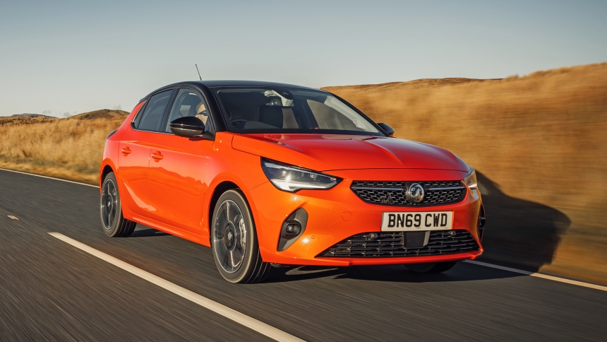 An image of an orange car driving in the countryside, to set the theme of the best time to sell a used car.